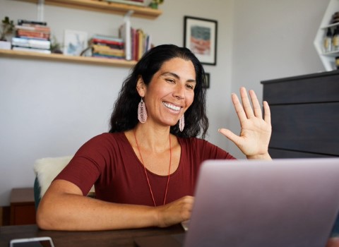 Person waving to others on video call