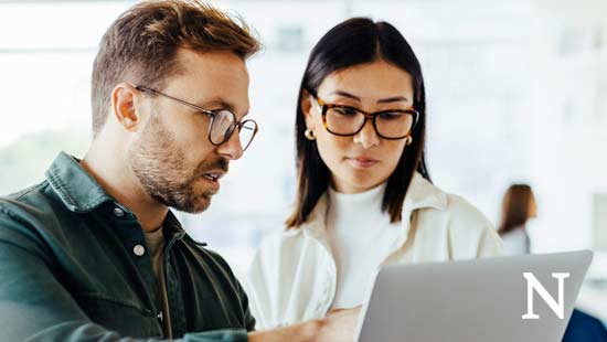 two people looking at a laptop