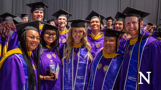 group of smiling graduates at graduation ceremony