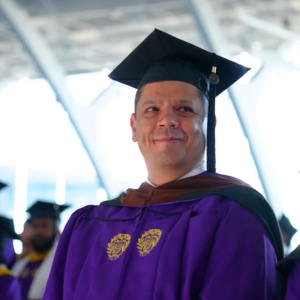 Ryan Rivera stands out at SPS convocation, wearing a Northwestern graduation cap and gown, looking hopeful.