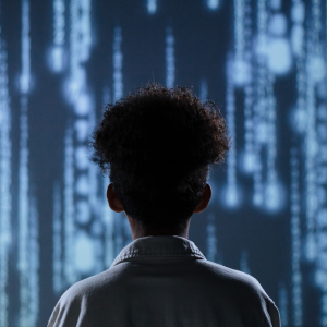 A silhouette of a child staring at a mega screen with lines of data and code. Learn how Northwestern's MS in Data Science addresses the harmful effects of data science through data science ethics.