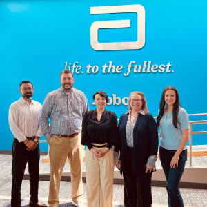 Öge Gözütok Moore and MS In Regulatory Compliance faculty director Carol Beirne with three associates at Abbott at their location near Chicago.