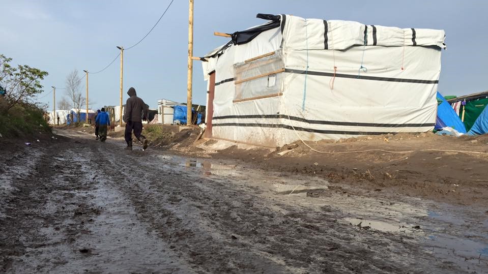 Man walking through a road in a refugee camp 